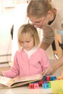 woman helping girl with textbook